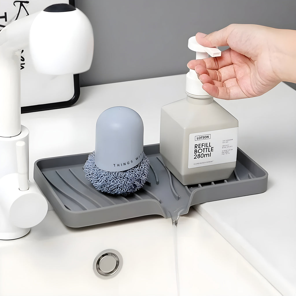 HomeShape grey silicone self-draining tray holding a soap dispenser and scrubber on a kitchen sink countertop