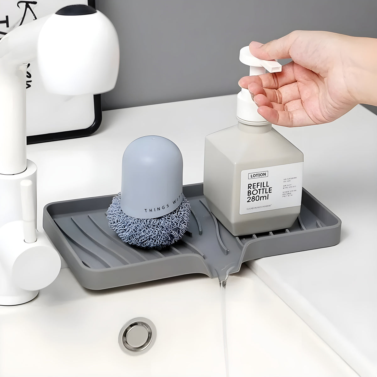 HomeShape grey silicone self-draining tray holding a soap dispenser and scrubber on a kitchen sink countertop